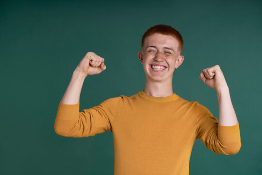Happy young ginger man celebrate success