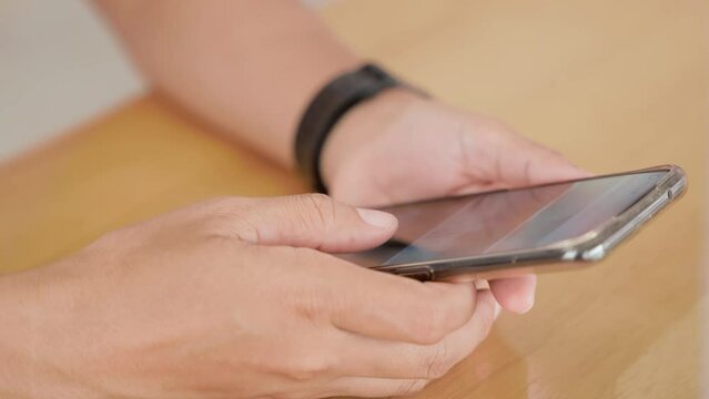 Hand of woman using application on smartphone she reading mail on social media at wooden teble, finger of happy female slide modern mobile phone screen, online internet searching