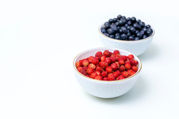 fresh, ripe, wild strawberries in a cup and blueberries in a cup. Forest gifts, berries