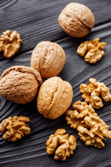 dried walnuts on a black rustic wooden background