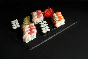 Asian cuisine dish, delicious sushi, sushi on a black background, roll you net on a black background