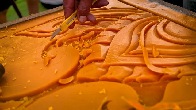 Artist using carving knife to carving candles for candle festival in Thailand.