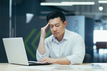 Fototapeta na wymiar Depressed businessman, boss working in modern office, thinking asian businessman sad, thinking about important decisions