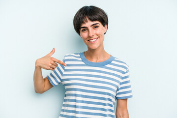 Young caucasian woman with a short hair cut isolated person pointing by hand to a shirt copy space, proud and confident