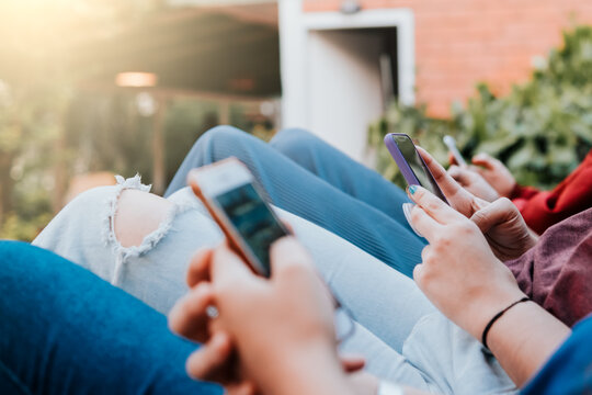 Group of multiracial friends using smartphones to sharing content on social networks. Technology lifestyle concept - Selective focus