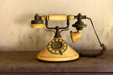 Old vintage phone on wooden table over dirty background