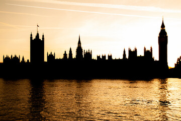 Westminster palace silhouette and river Thames at sunset in London, England