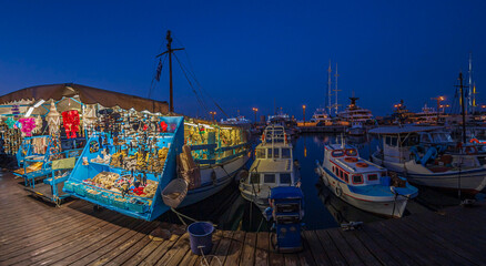 Fototapeta na wymiar Night view with yachts and boats with souvenirs in port Mandraki marina, Rhodes, Greece