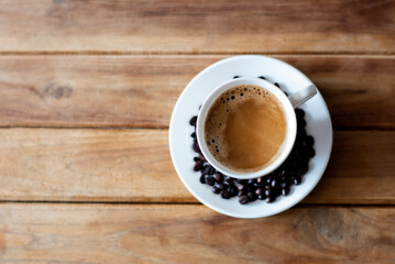 Coffee cup with beans on wooden table. Top view. Selective focus.