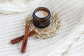 Soy wax candle in amber glass with cinnamon sticks