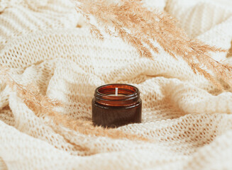 Soy wax candle in amber glass with dried flowers.