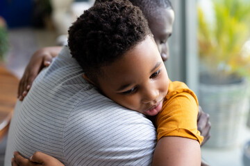 Image of african american father and son hugging