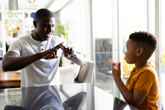 Image of african american father and son using sing language