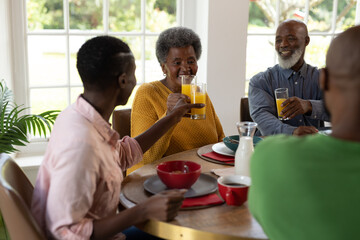 Fototapeta na wymiar Image of happy multi generation african american family eating breakfast