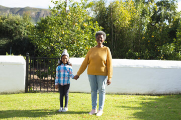 Image of happy african american grandmother and granddaughter in garden - Powered by Adobe