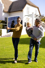 Vertical image of caucasian father with solar panel, grandfather and grandson