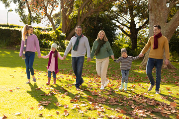 Image of nappy multi generation caucasian family spending time in autumn garden