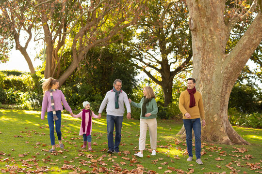 Image of nappy multi generation caucasian family spending time in autumn garden