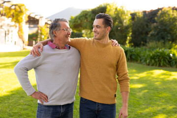 Obraz premium Image of happy caucasian father and adult son in garden