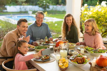 Image of multi generation caucasian family eating outdoor dinner