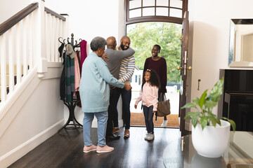 Image of happy multi generation african american family entering house and welcoming each other