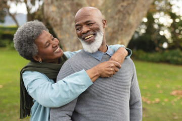 Image of happy african american senior couple posing at camera outdoors in autumn - Powered by Adobe