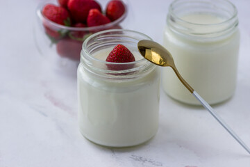Healthy food at home. Homemade yogurt with strawberries in glass jars