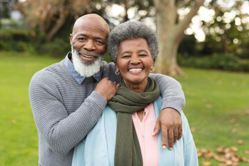 Image of happy african american senior couple posing at camera outdoors in autumn - Powered by Adobe
