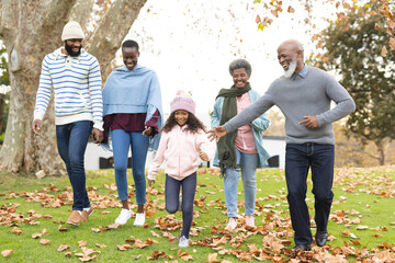 Image of happy multi generation african american family having fun outdoors in autumn - Powered by Adobe