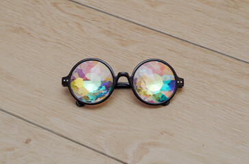 designer glasses with kaleidoscope lenses on wooden background