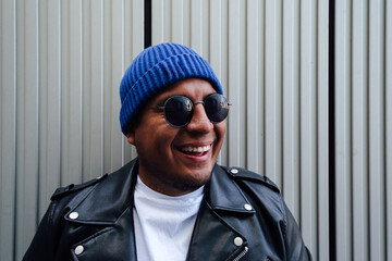 Portrait of a Latin man smiling with perfect teeth and cool sunglasses.