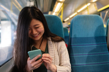Woman holding mobile phone on train.