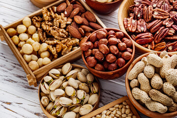 set of different nuts on a white wooden rustic background