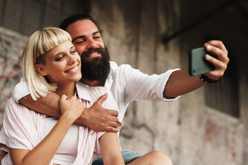 Young happy couple taking a selfie in an urban environment