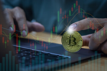 Close-up of businessman finger pointing at digital currency Overlaid with candlestick charts. The statistical line shows the growth on the laptop. Concept of data analysis for valuation of investment 