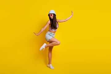 Fototapeta na wymiar Full body image of young attractive slender lady have fun during her summer vacation isolated on yellow color background
