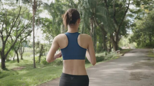 Young Asian women are exercising with outdoor running with a mountain and lake background in the morning. Concept healthy running and outdoor exercise,Tracking shot, 4k resolution.