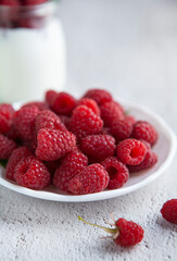 macro of raspberries in a white bowl on the table