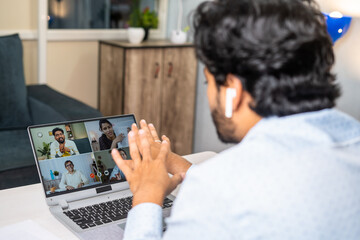 Young businessman making conference video call with colleagues on laptop at office - concept of online training, corporate meeting and project briefing
