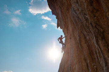 Rock climber on the background of blue sky
