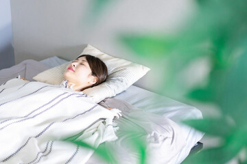 ベッドで熟睡する若い女性