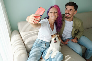 Happy hipster couple with their rough coated dog. Young woman with pink purple hair and her bearded...