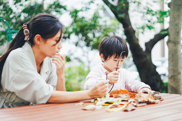 葉っぱで遊ぶお母さんと息子