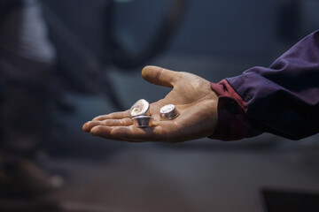 Man holds samples of silver metal.
