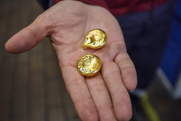 Man holds samples of gold metal.