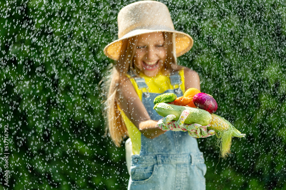 Wall mural child with vegetables. happy little girl holding vegetables in her hands. high quality photo