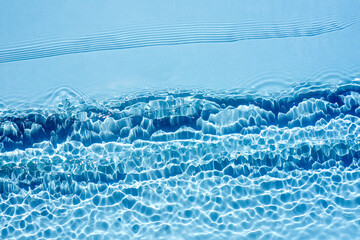 Background, texture of transparent blue water with seething ripples , waves