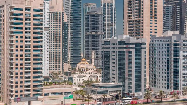 Dubai Marina skyline with Mohammad Bin Ahmed Al Mulla mosque aerial timelapse. Skyscrapers around with glass surface on a background and traffic on the road