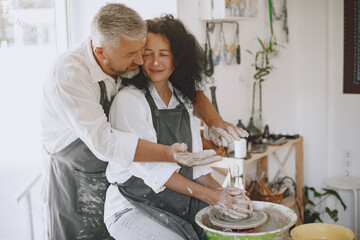 Adult senior couple at artwork in pottery