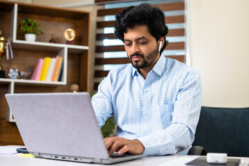 Thoughtful Young corporate employee working laptop while sitting at office - concept of work...